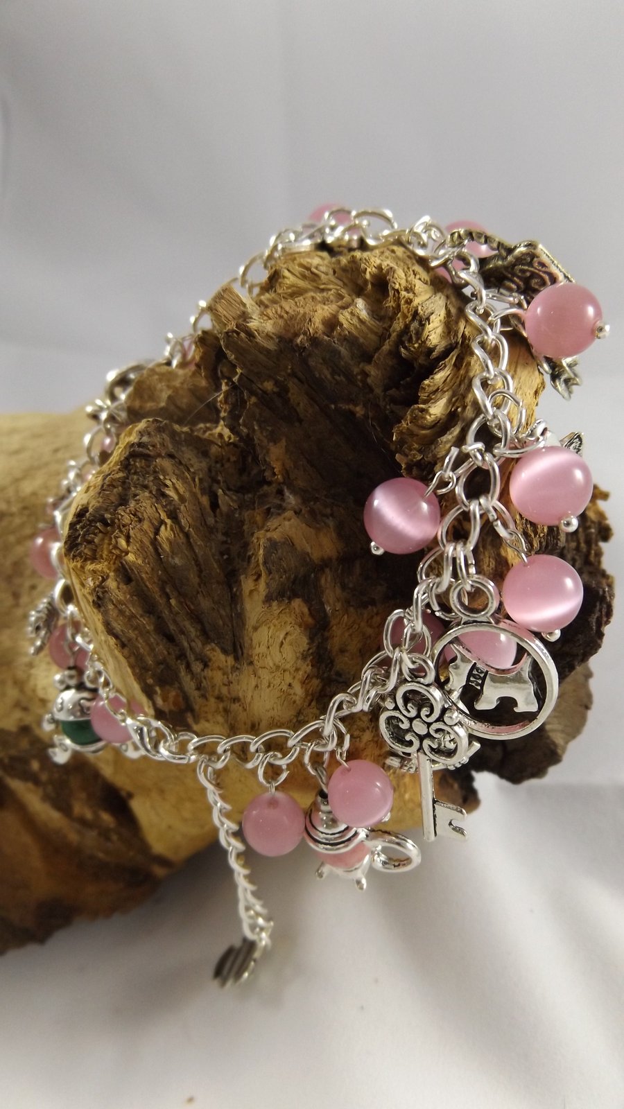 Silver plated charm bracelet with pink cats eye beads
