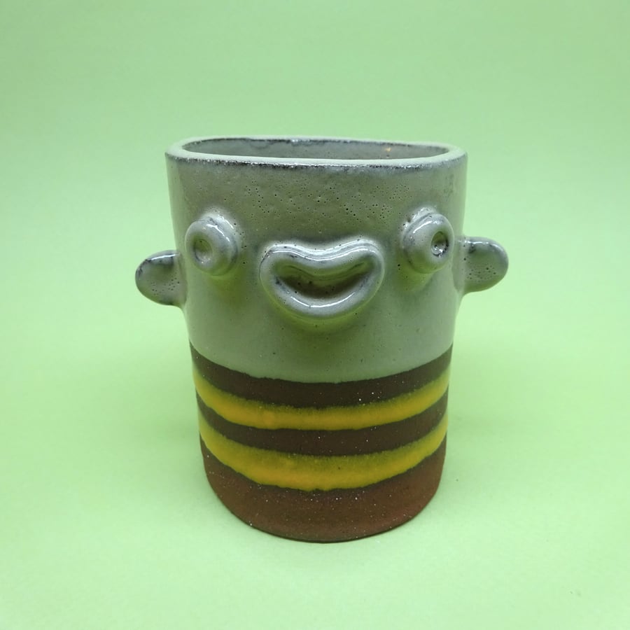 Ceramic face pot with sticking out ears and stripy top