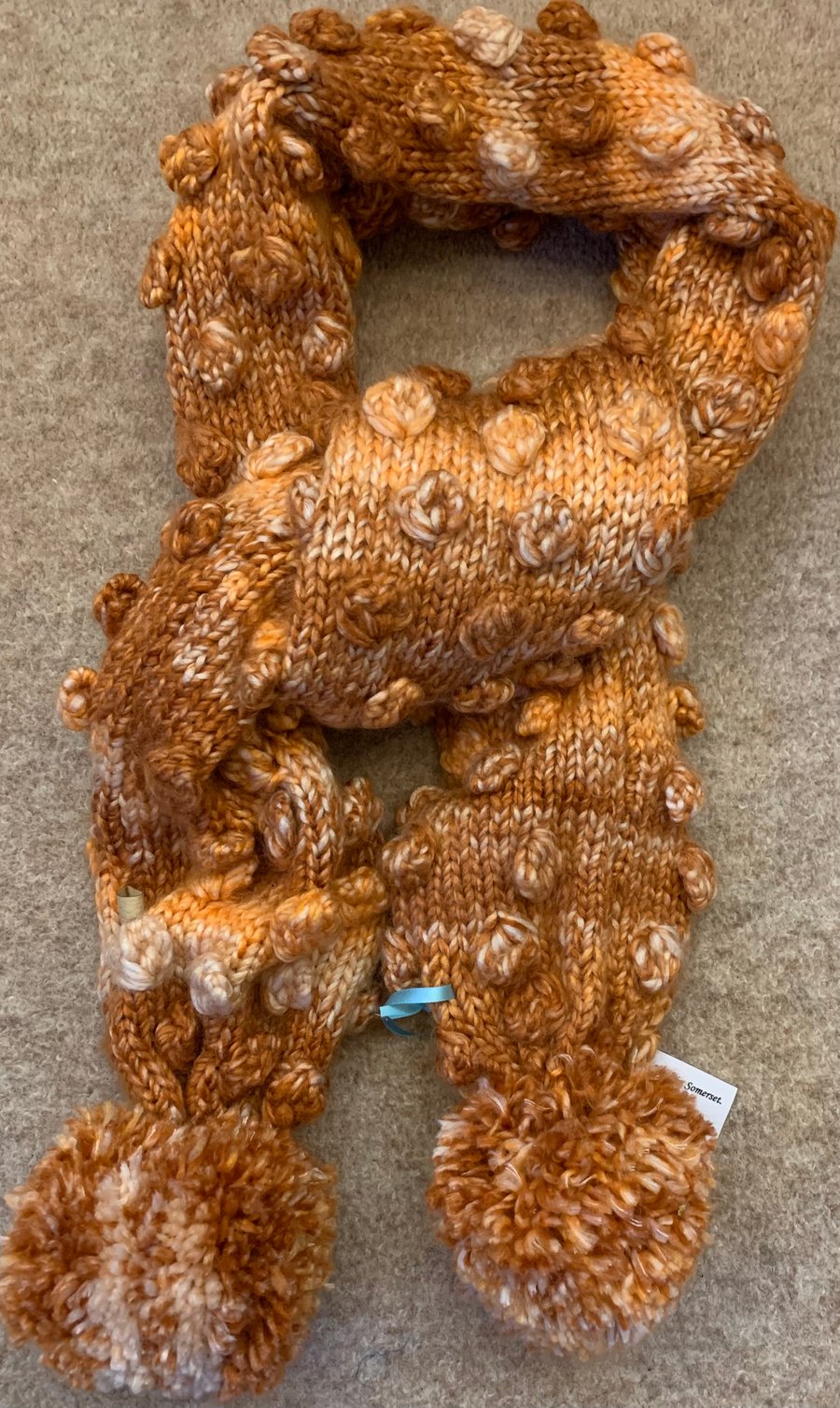 Hand Knitted Bobble Scarf in a Rust Colour 