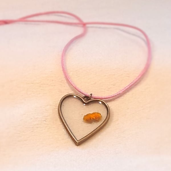 Heart shaped pendant with yellow flower inclusion