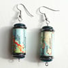 Paper beaded earrings with iridescent and blue beads made with a map of Norway