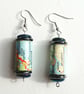 Paper beaded earrings with iridescent and blue beads made with a map of Norway