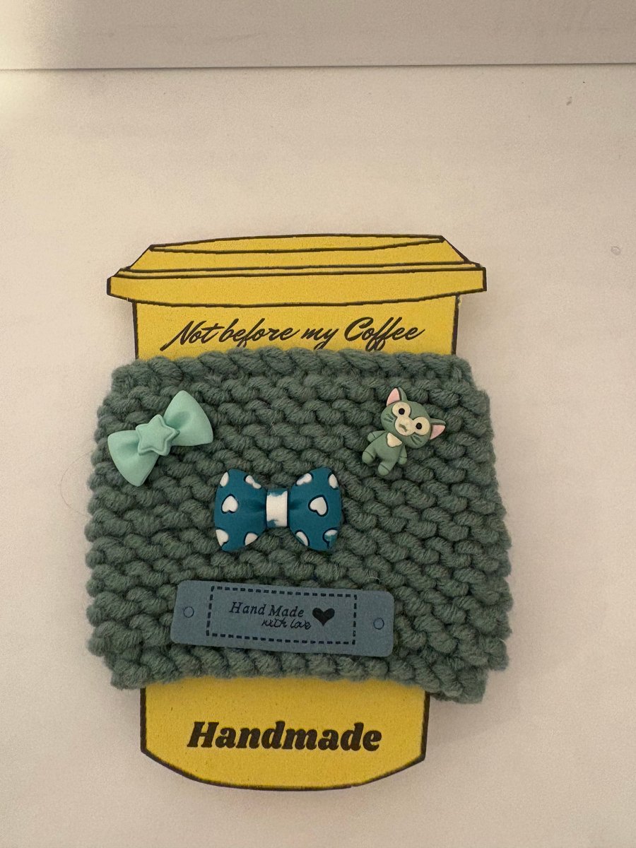 Green bows and cat knitted cup cosy. 