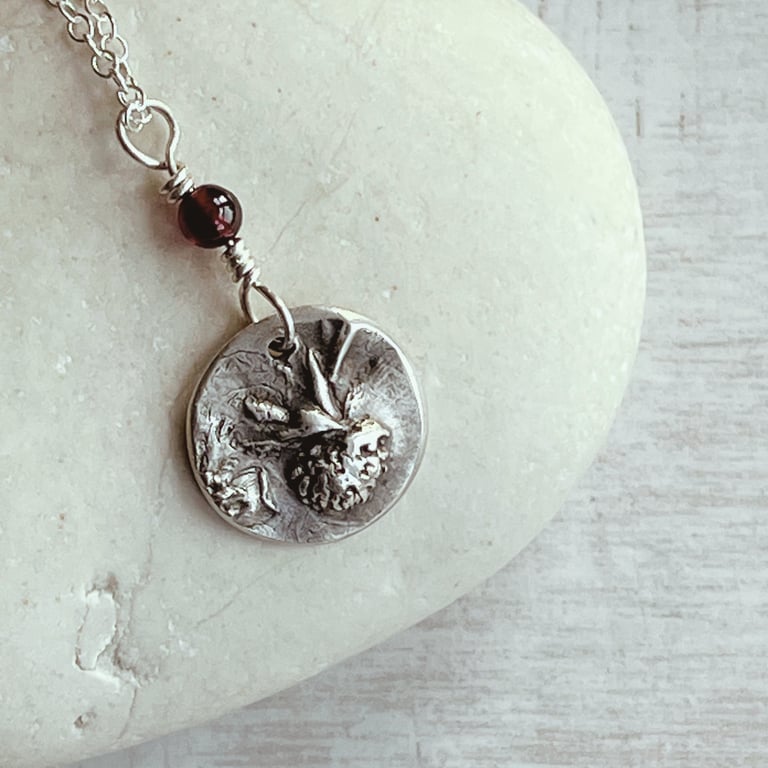 Botanical silver pendant with strawberry design.
