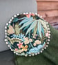 Round feature cushion in vintage leafy linen with pompoms - Image 2