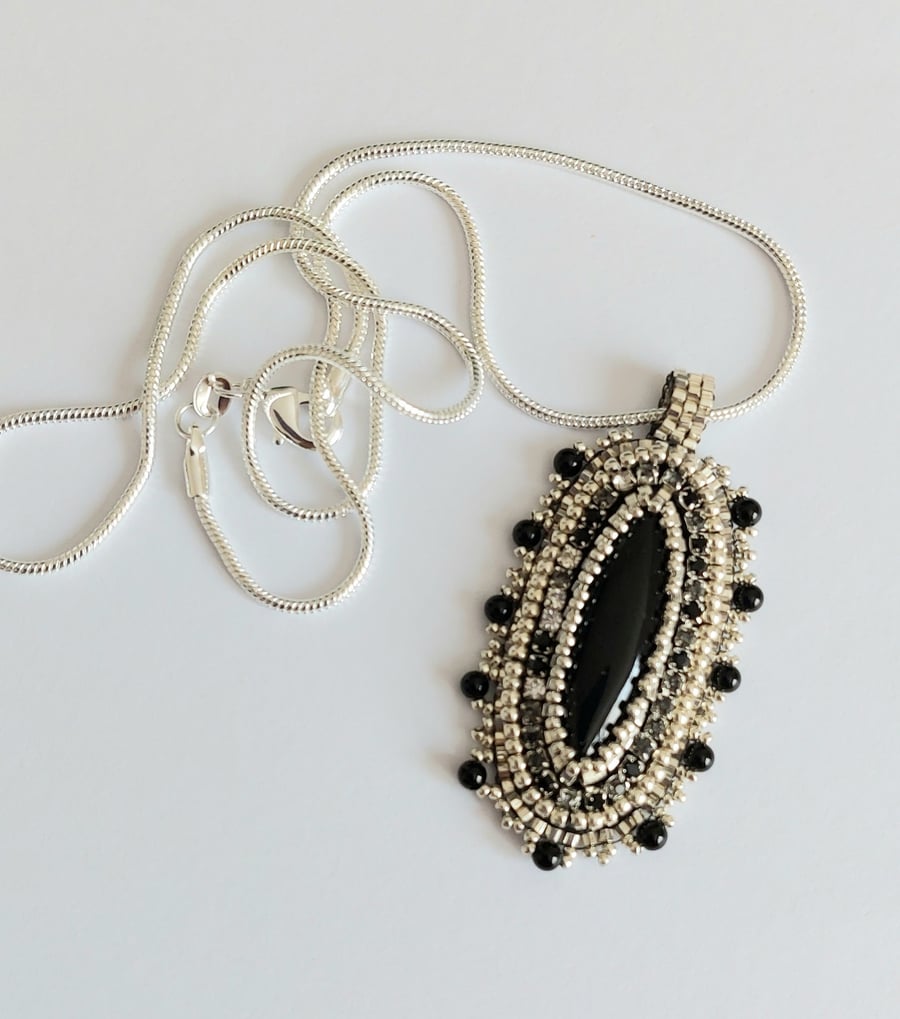 Bead embroidered Black Agate pendant on a silver tone chain     