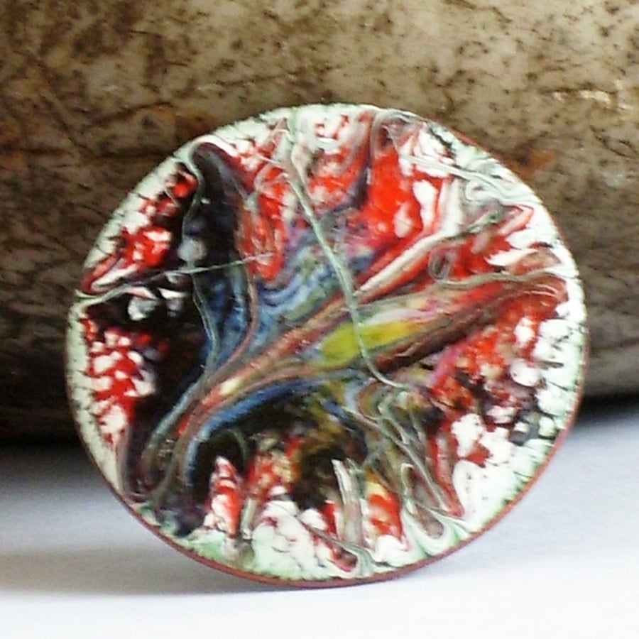 round brooch scrolled black and yellow on red over white