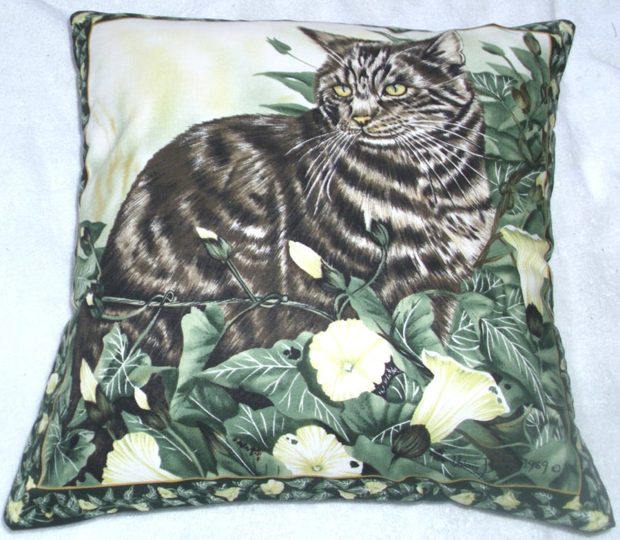 Beautiful tabby cat sitting among flowering ivy cushion