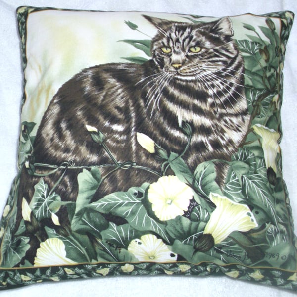 Beautiful tabby cat sitting among flowering ivy cushion