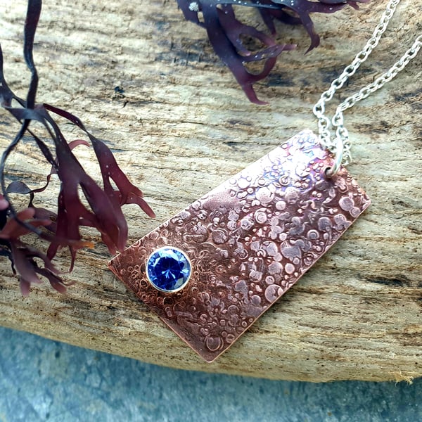 Copper pebble textured pendant with blue stone
