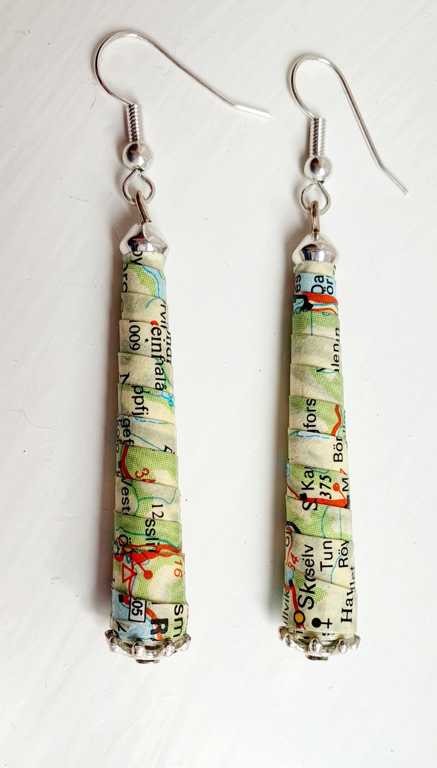 Long,  thin, conical paper beaded earrings made with an old map of Norway