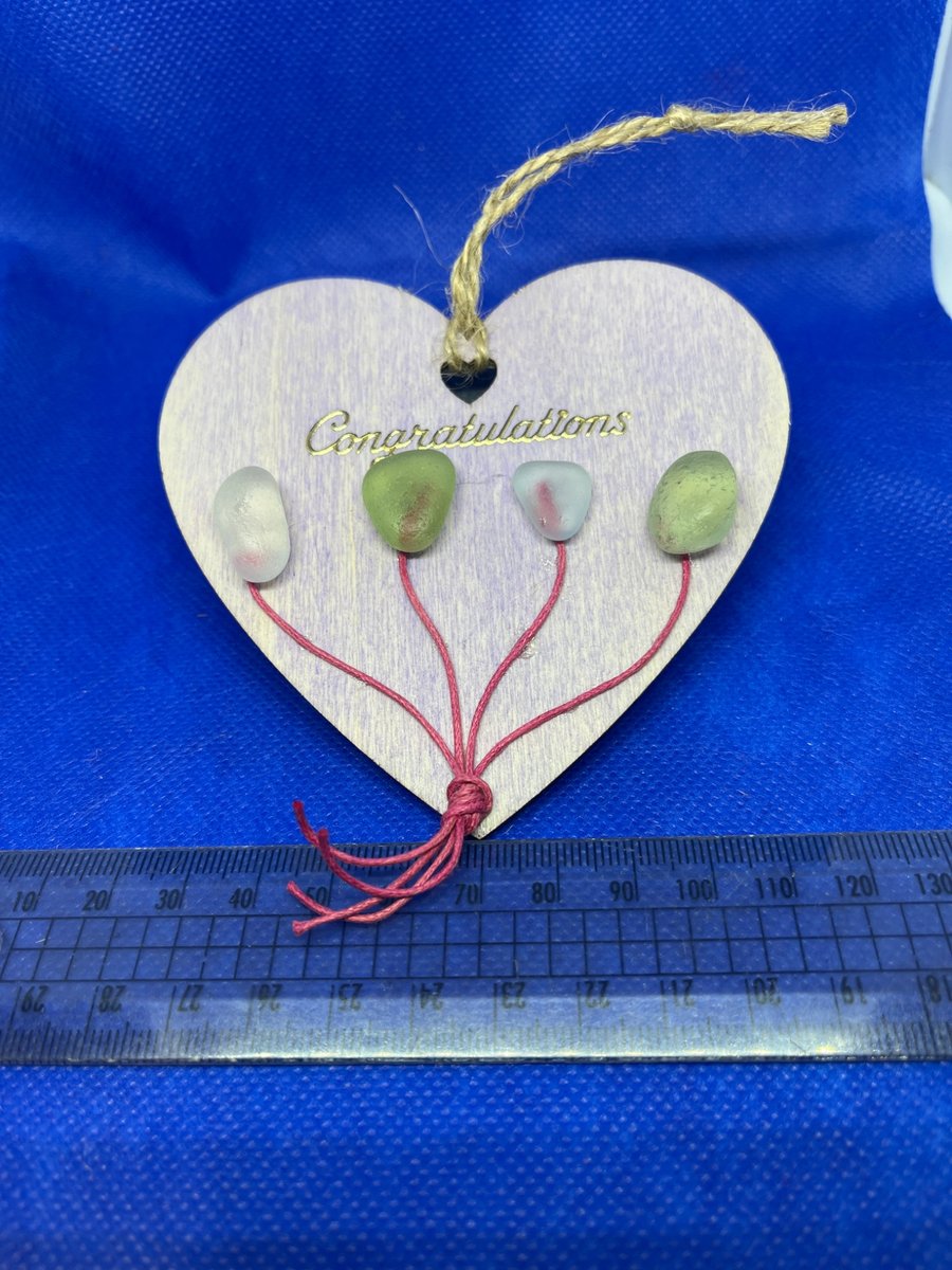 Wooden heart with 'congratulations' sentiment made  with sea glass.