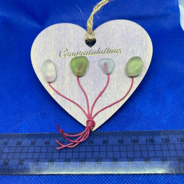 Wooden heart with 'congratulations' sentiment made  with sea glass.