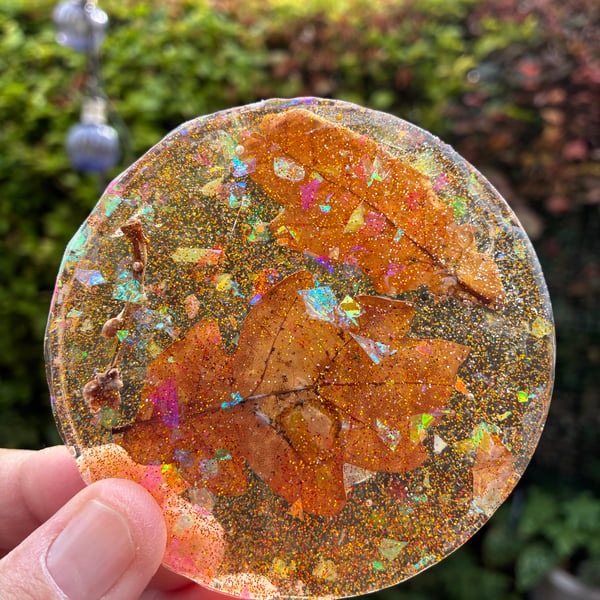 Resin coaster with dried beech leaves and twig swirled with glitter sprinkles