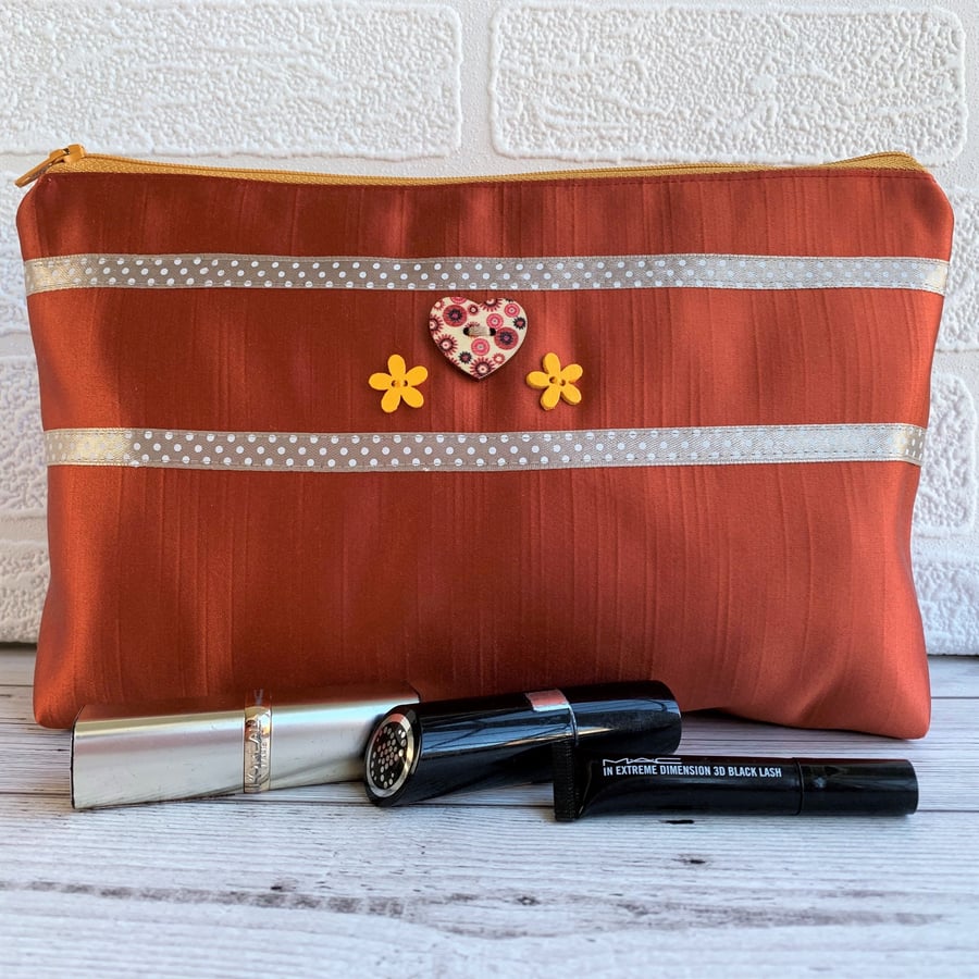 Large make up bag in burnt orange satin trimmed with ribbon and buttons