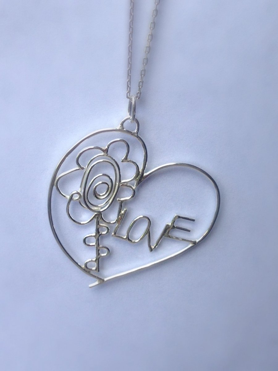 A personalised bespoke sterling silver pendant from two childrens drawings