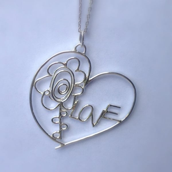 A personalised bespoke sterling silver pendant from two childrens drawings