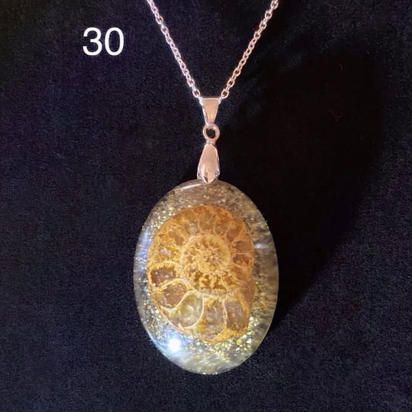 Ammonite necklace laid on a bed of sand 