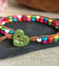 Multicoloured howlite bead and leather bracelet with green ceramic heart button - Image 1
