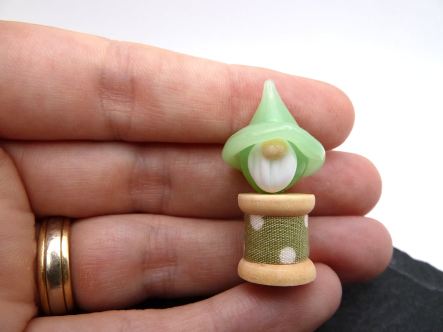 small glass bobbin, green gnome