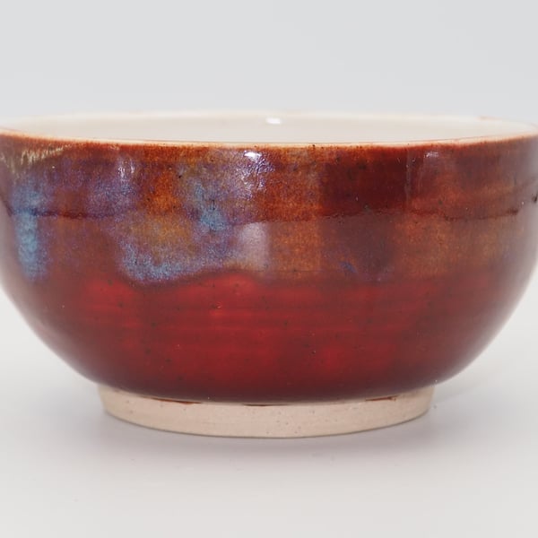 Stoneware Japanese inspired tea bowl, red with blue accents.