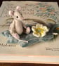 Miniature mouse 'Primrose' fully jointed, hand stitched sitting on a silk leaf.