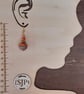 Handmade dangly polymer clay earrings in an orange swirl  design - Image 3