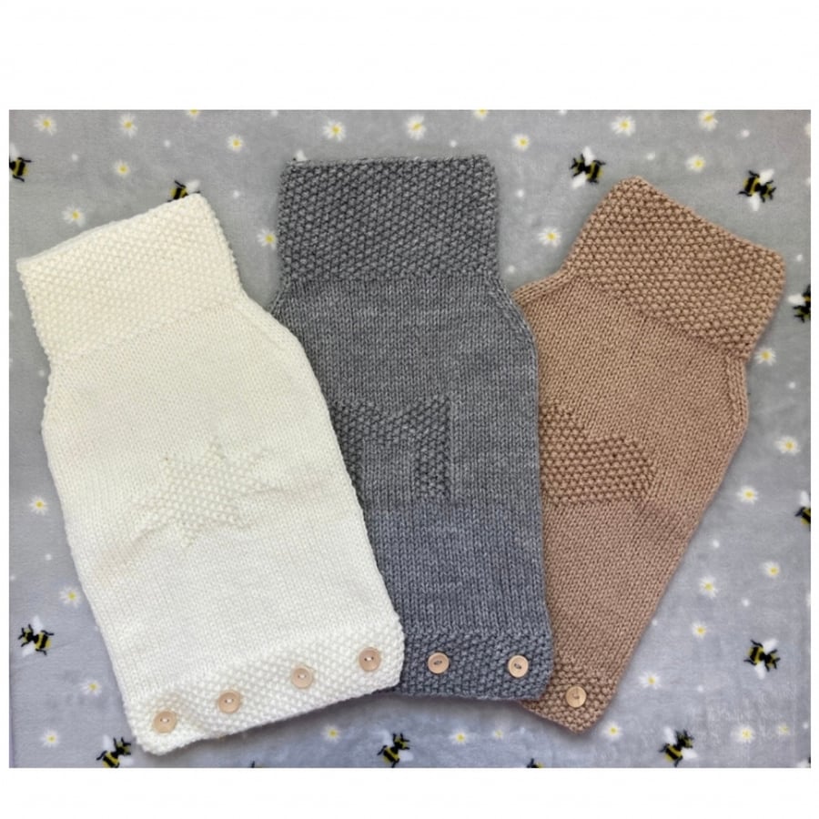 Knitted hot water bottle covers in cream, brown or grey.
