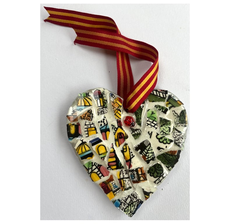 A heart shaped mosaic pendant with vibrant greens, yellows, blues, and pinks.