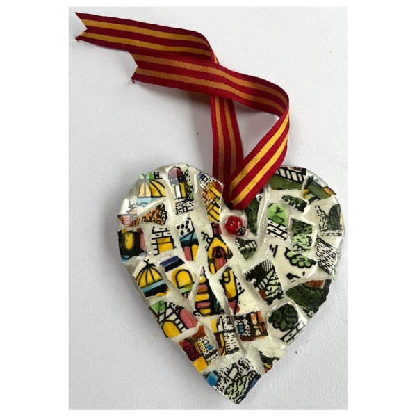 A heart shaped mosaic pendant with vibrant greens, yellows, blues, and pinks.