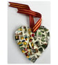 A heart shaped mosaic pendant with vibrant greens, yellows, blues, and pinks.