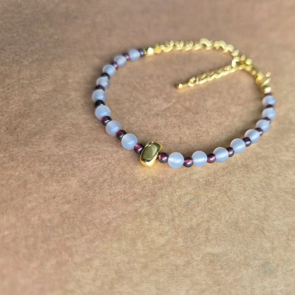 Owl grey and deep red, centre stone bracelet in gold.