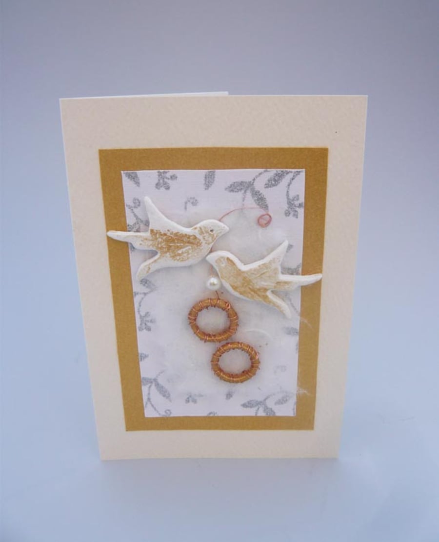 Wedding card with gold rings and birds.