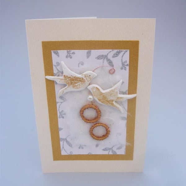 Wedding card with gold rings and birds.