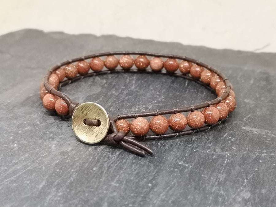 Goldstone bead and brown leather bracelet with button fastener