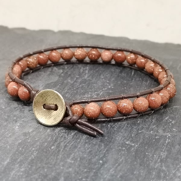 Goldstone bead and brown leather bracelet with button fastener