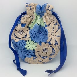 Small, drawstring Potli, wristlet bag, lace flowers on blue.