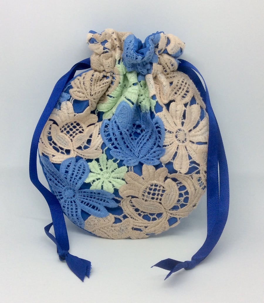 Small, drawstring Potli, wristlet bag, lace flowers on blue.