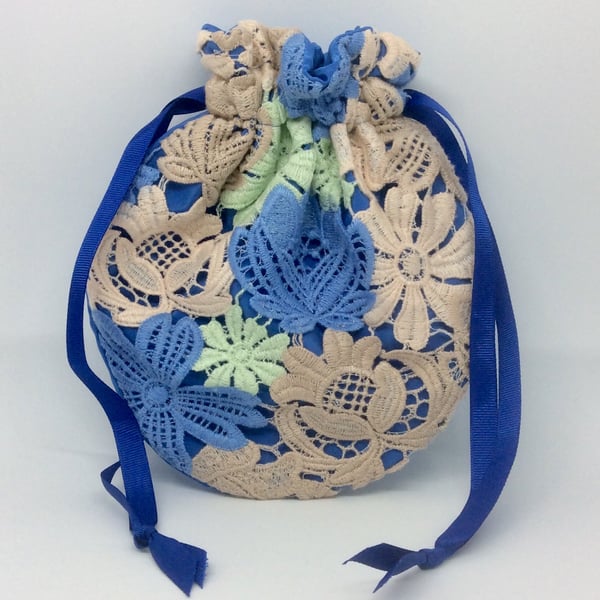 Small, drawstring Potli, wristlet bag, lace flowers on blue.