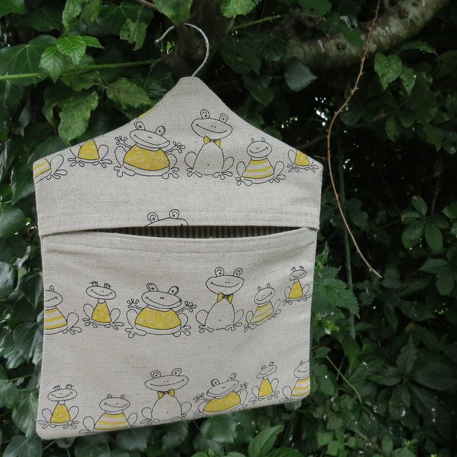 A peg bag with a quirky frogs design.  Peg storage.
