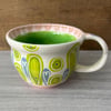 Handthrown pottery teacup in shades of blue, green and pink