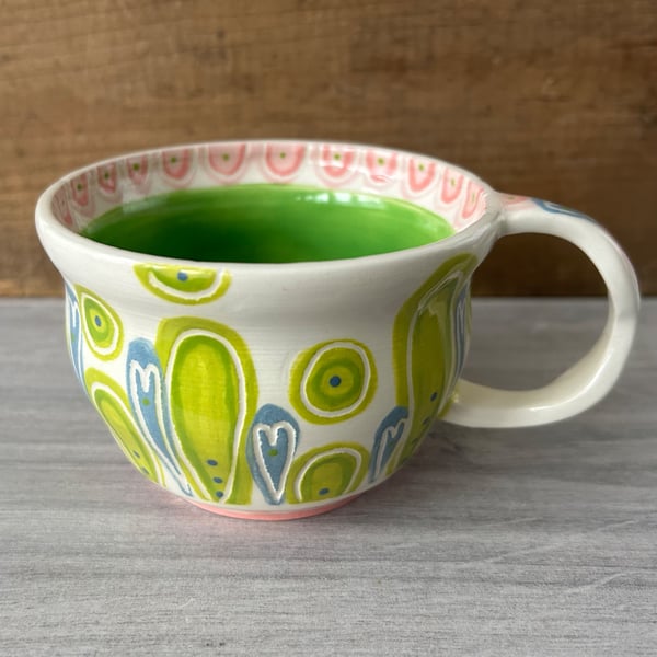 Handthrown pottery teacup in shades of blue, green and pink