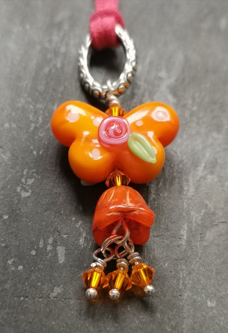 SALE orange butterfly pendant with Swarovski crystals on pink faux suede