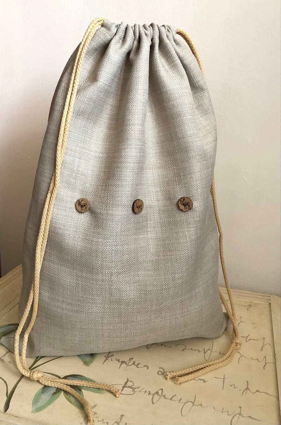 Strong drawstring bag in natural linen look fabric with cord.