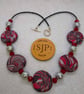 Disc shaped necklace in a red, black and silver swirl design - Image 3