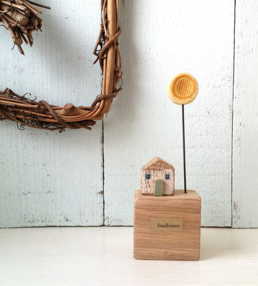 Little wooden house block with yellow clay sunflower