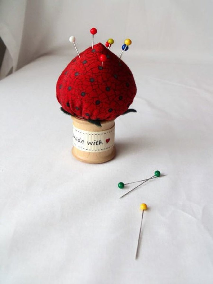 novelty strawberry pin cushion on a vintage wooden bobbin