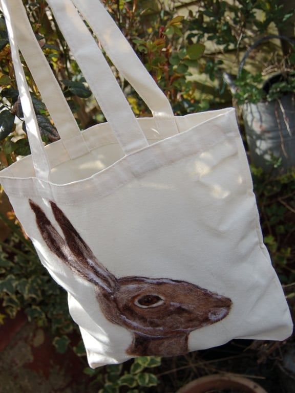 A needle felted hare portrait on a Canvas tote bag.