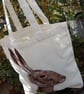 A needle felted hare portrait on a Canvas tote bag.