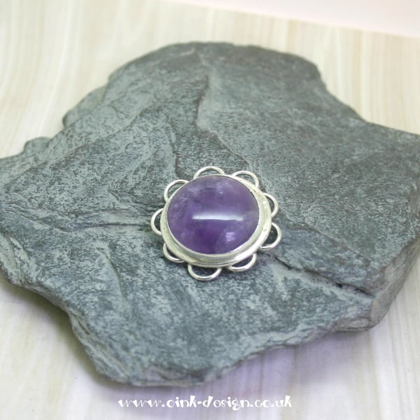 Amethyst pendant set in a sterling silver flower design setting